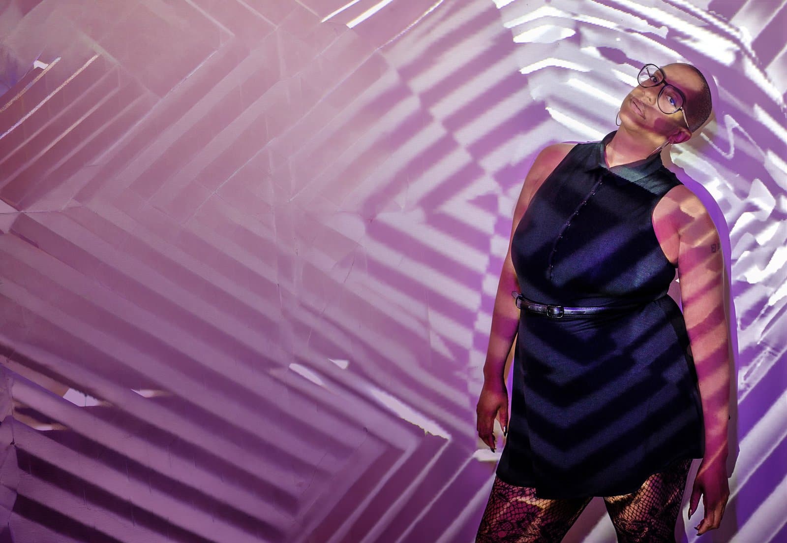 Sharlese in front of a projected geometric pattern